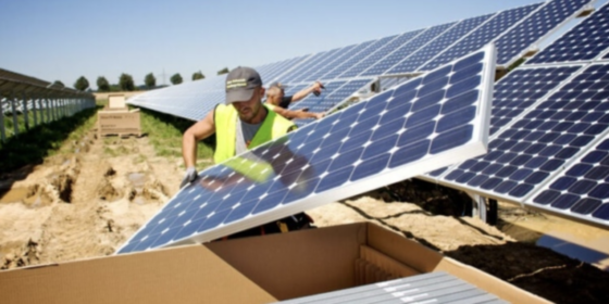 Photo of a worker installing solar panels